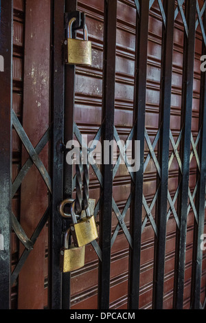 Plusieurs cadenas sécuriser une porte métallique coulissante du magasin à Sucre, Bolivie. Banque D'Images