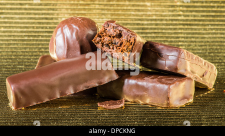 Bonbons de chocolat noir.Gold shiny background Banque D'Images