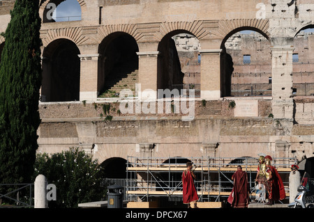 Groupe de soldats Romains debout à l'extérieur du Colisée de Rome, Italie. Le Colisée est en construction. Banque D'Images