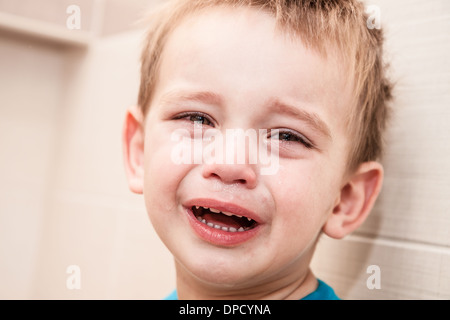 Portrait de bébé qui pleure garçon dans la maison. Banque D'Images