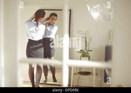 Belle femme d'affaires s'habiller pour le travail en face du miroir à la maison. Portrait modèle féminin en tenue d'affaires. Banque D'Images