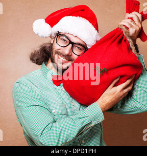 Guy holding un cadeau et émotionnellement Joyeux Noël Banque D'Images