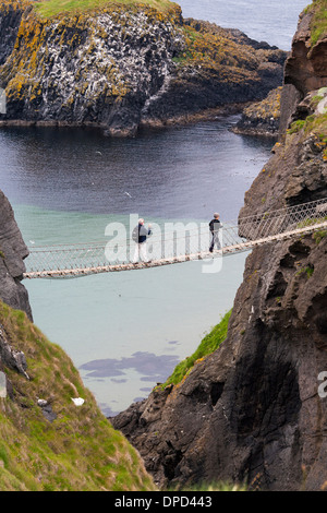 De haut en bas le Carrick-a-rede Rope Bridge sur la côte d'Antrim en Irlande du Nord en tant que visiteur marche à travers. Banque D'Images