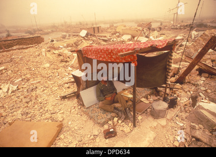 Iran guerre en Irak également connue sous le nom de première Guerre du Golfe persique ou Guerre du Golfe. 1984 Soldat se remettant d'une bataille récente, à l'abri de la chaleur et de la tempête de sable parmi les dévastations de la guerre, près de Bassorah sud de l'Irak. HOMER SYKES des années 1980 Banque D'Images