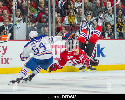 Chicago, Illinois, USA. 12Th Jan, 2014. 12 janvier 2014 - Chicago, IL, États-Unis d'Amérique - le 12 janvier 2014 : Chicago, Illinois, États-Unis - Blackhawk # 20 Brandon Saad est suspendu par Oiler # 64 Nail Yakupov durant la partie de la Ligue nationale de hockey entre les Blackhawks de Chicago et les Oilers d'Edmonton à l'United Center de Chicago, IL. © csm/Alamy Live News Banque D'Images