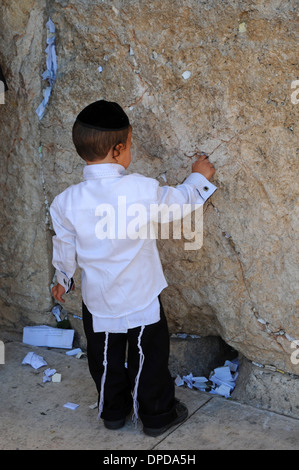 Enfant religieux touchant le mur occidental, à Jérusalem, Israël Banque D'Images