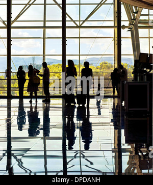 Silhouettes d'méconnaissable les gens du voyage à l'aéroport en face de l'immense fenêtre avec nature paysage en arrière-plan Banque D'Images