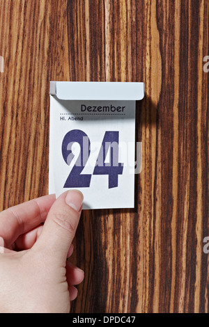 Arrachant des mains de feuille de calendrier 24 Décembre Banque D'Images