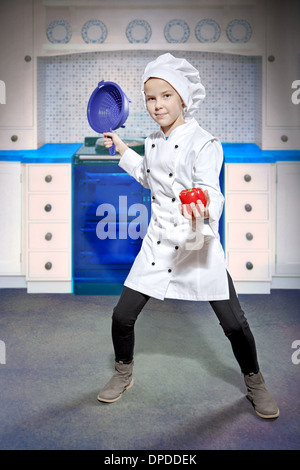 Jeune femme cuisinière avec une passoire et le paprika Banque D'Images