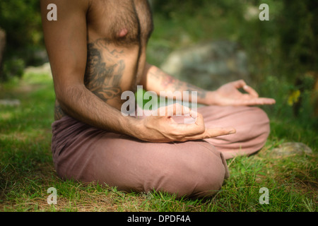 Un jeune homme se pratique le yoga et la méditation dans une paisible forêt de l'Himalaya. Banque D'Images