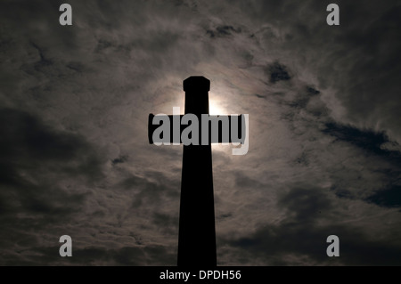 Croix du sacrifice silhouetté contre le ciel à un cimetière de guerre du Commonwealth, France Banque D'Images