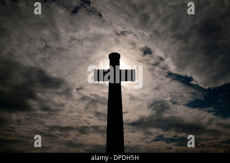 Croix du sacrifice silhouetté contre le ciel à un cimetière de guerre du Commonwealth, France Banque D'Images