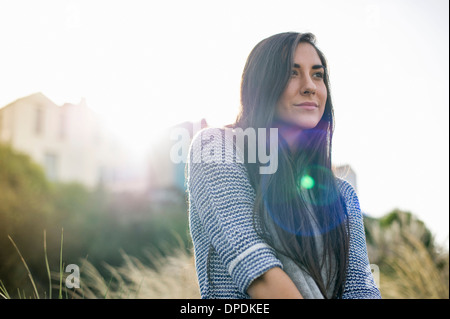 Jeune femme aux longs cheveux bruns à la lumière du soleil Banque D'Images