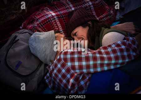 Mature couple lying down, serrant sur tapis de pique-nique Banque D'Images