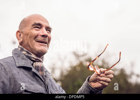 Senior man gesturing avec des lunettes Banque D'Images