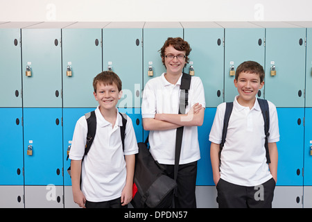 Portrait de trois garçons à côté des casiers de l'école Banque D'Images