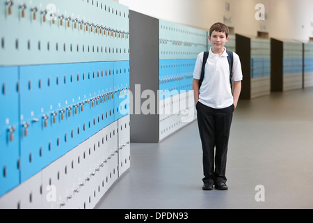 Portrait d'écolier avec les mains dans les poches en couloir d'école Banque D'Images