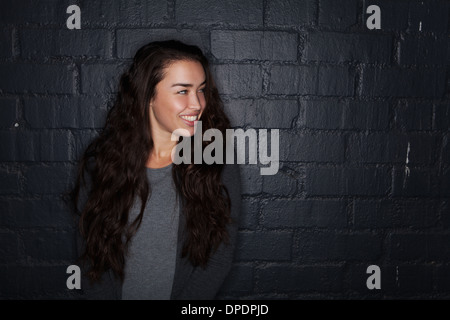 Jeune femme black brick wall Banque D'Images