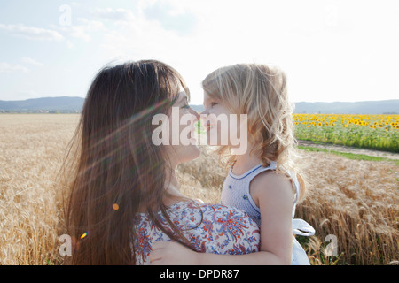 Mère et fille en champ de blé hugging Banque D'Images