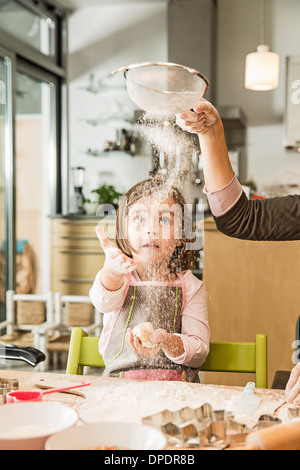 Mère et fille de tamisage de la farine en cuisine Banque D'Images