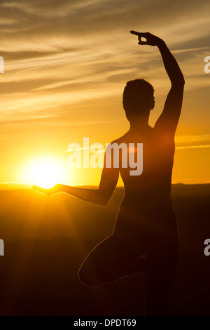 Jeune femme faisant du yoga à la lumière du soleil, Moab, Utah, USA Banque D'Images
