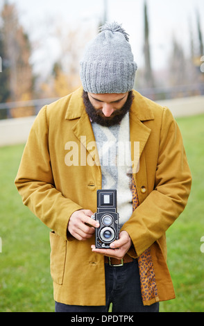 Les jeunes phoques barbus hipster taking photo avec l'appareil photo à l'extérieur des TLR Banque D'Images