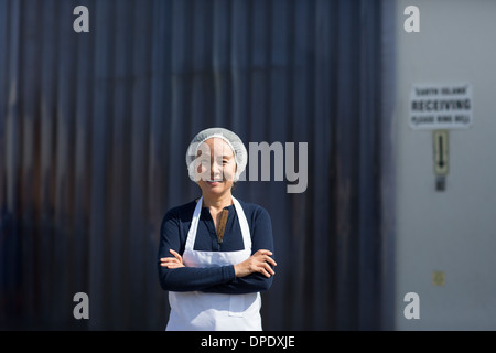 Portrait de femme employée d'usine, les bras croisés Banque D'Images