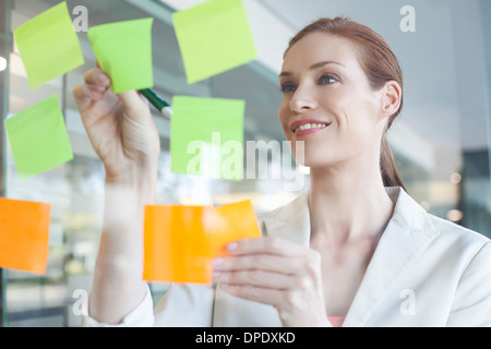 Businesswoman brainstorming en utilisant les notes Banque D'Images