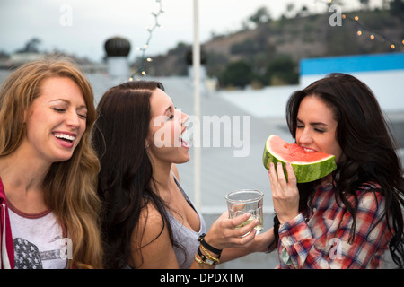 Trois jeunes femmes à barbecue avec grande tranche de melon Banque D'Images
