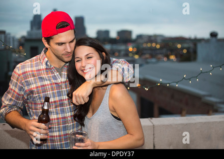 Young couple having fun at rooftop barbecue Banque D'Images