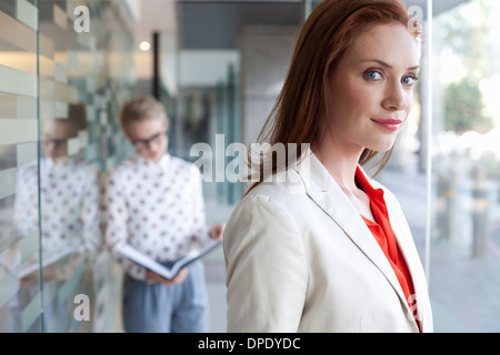 Portrait of businesswoman with colleague in background Banque D'Images