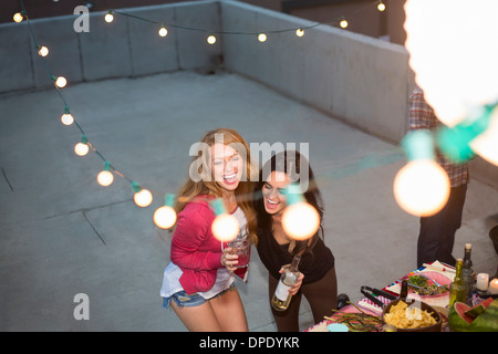 Deux femmes friends dancing at rooftop party Banque D'Images