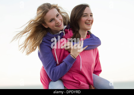 Deux jeunes femmes friends having fun on beach, Whitstable, Kent, UK Banque D'Images