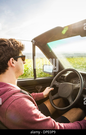 Young man leaning driving convertible Banque D'Images