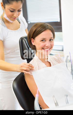 Jeune femme en dentistes chaise avec infirmière dentaire Banque D'Images