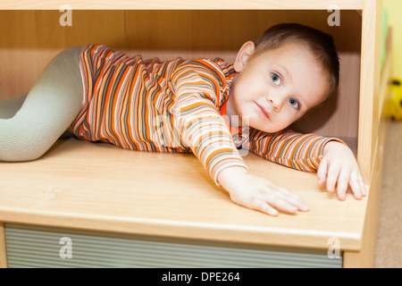 Cute child boy hiding dans une armoire à la maison Banque D'Images