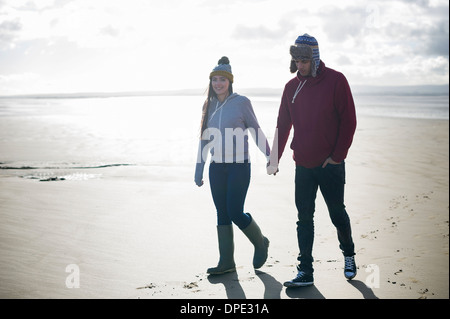 Jeune couple walking on beach, Brean Sands, Somerset, Angleterre Banque D'Images