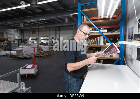 Contrôle de la qualité de travailleur imprimer produits en atelier d'impression Banque D'Images