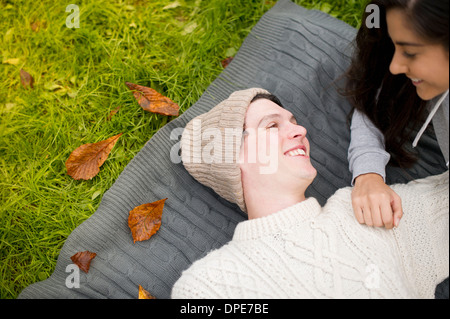 Jeune couple allongé sur le tapis, man wearing Knit hat Banque D'Images