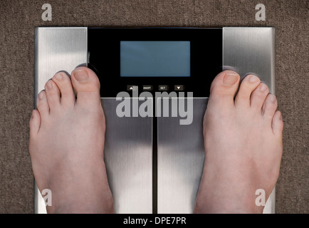 Les pieds de l'homme pèse sur tapis photographié d'en haut avec un écran vide Banque D'Images