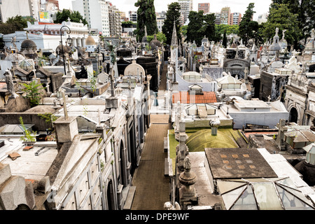 Cimetière de Recoleta Mausolées Buenos Aires Argentine // BUENOS AIRES, Argentine — le cimetière de Recoleta, l'une des nécropoles les plus visitées d'Amérique du Sud, est visible à travers une fenêtre de la basilique notre-Dame de Pilar. Le cimetière, créé en 1822, contient des mausolées élaborés abritant des vestiges d'Argentins notables, dont Eva Perón. La basilique adjacente, achevée en 1732, compte parmi les plus anciennes églises de Buenos Aires et présente une architecture baroque coloniale. Ensemble, ces monuments forment le cœur historique du quartier chic de Recoleta. Banque D'Images