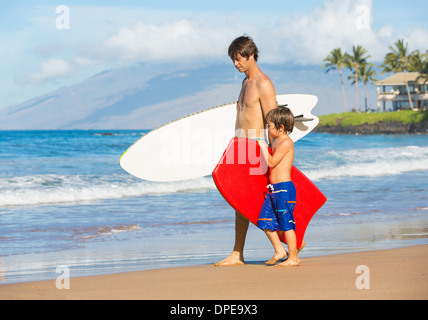 Père et fils aller surfer ensemble sur la plage tropicale à Hawaï Banque D'Images