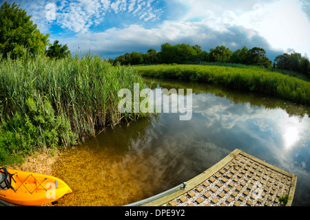 Marais paisible avec une rampe d'eau, kayak orange, reflets de ciel, un paisible paysage à 180 degrés de l'œil de poisson Long Island, NY US Banque D'Images