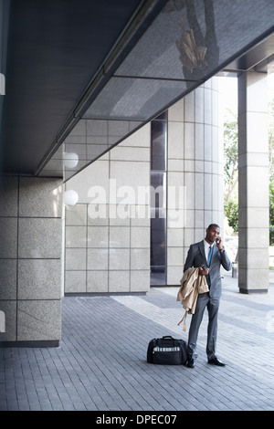 Businessman standing outside avec sac et enduire Banque D'Images