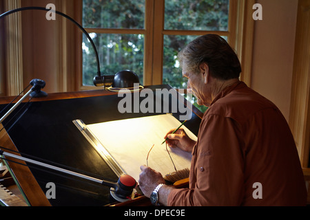 Man travaille sur le dessin architectural à la maison Banque D'Images