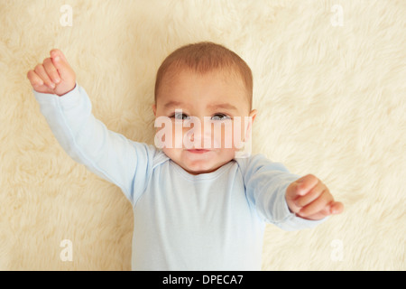 Bébé couché sur un tapis en peau de mouton Banque D'Images