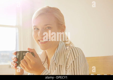 Jeune femme tenant une boisson chaude Banque D'Images