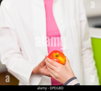Jeune fille donnant dentiste apple, Close up Banque D'Images
