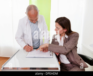 Les professionnels de discuter de dossiers médicaux Banque D'Images