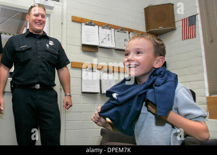 (Publié le 5/19/2006, le NI-4) le 12 mai 2006, San Diego (Californie), Rancho Bernardo 8 ans WESLEY McCORD tente sur un San Diego Pompiers t-shirt remis par les pompiers ici à S.D.F.D.'s station 33 c'est dans le besoin de rénovation. À gauche est pompier JIM ZALESKI. Wesley a été la première personne à donner de l'argent à l'effort communautaire visant à recueillir des fonds pour la station. Banque D'Images